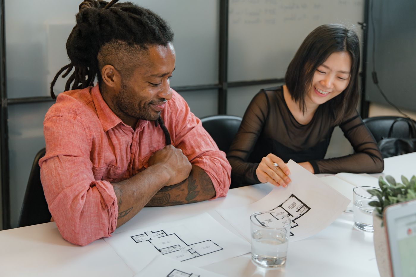 Two colleagues reviewing a floor plan together at a studio table
